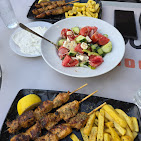 Table with souvlaki, salad and fries